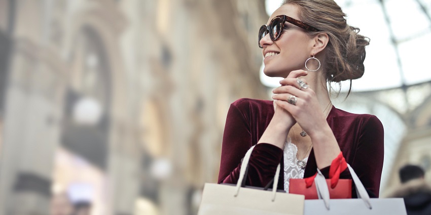 Picture of a girl carrying shopping bags in their hands inside a mall.