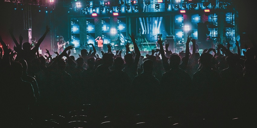 People raising their hands dancing to the energetic music played in the club