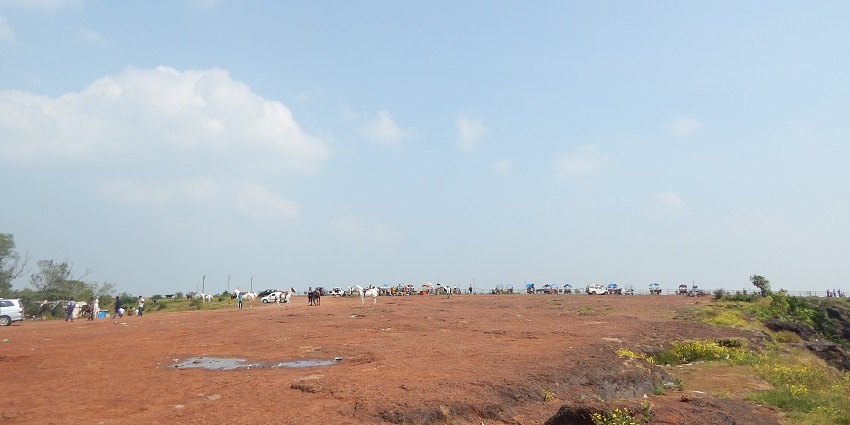 A vast landscape adorned with lush greenery and occasional rocky outcrops on land.