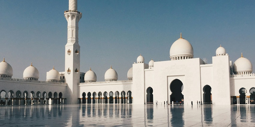 An image of the majestic Taj-ul-Masajid with its grand domes and minarets.