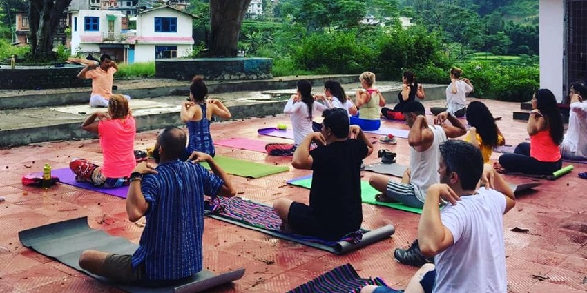 Group of people practising yoga outdoors in Pune, showcasing a vibrant wellness scene.