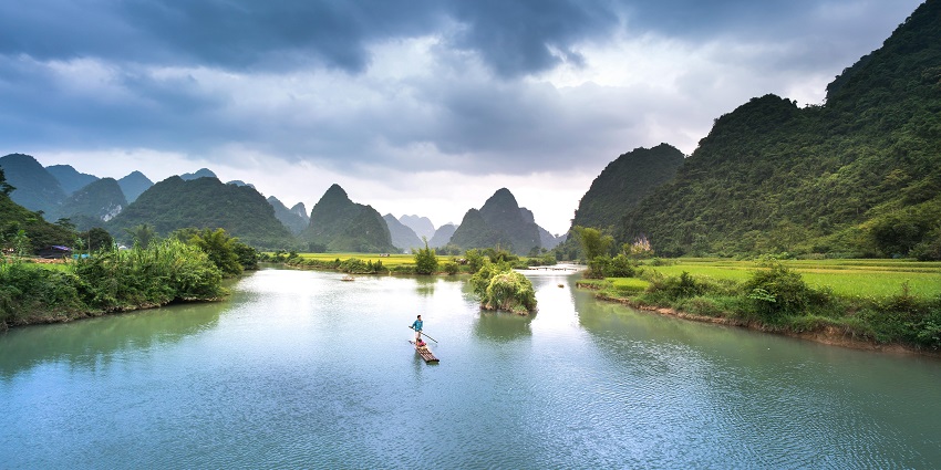 Image of a man on boat in lake surrounded by lush greenery - Talegaon lake one of the best places to visit in Talegaon