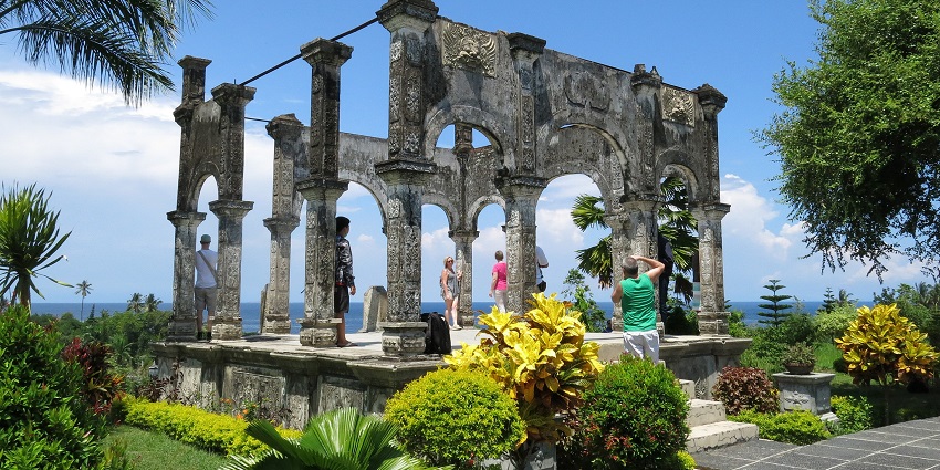 An image showcasing Taman Soekasada Ujung's lush gardens and traditional Balinese design.