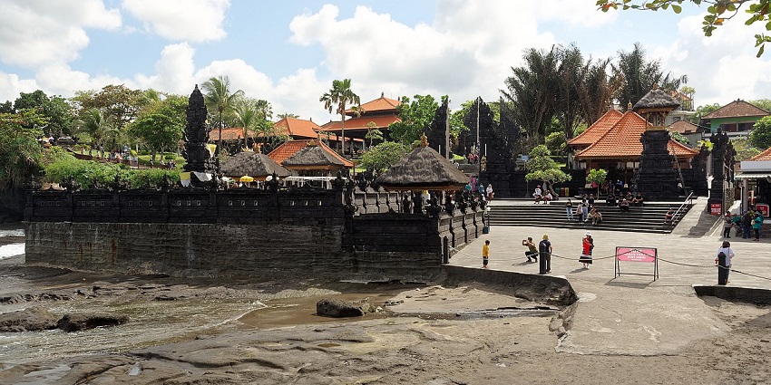 An image of the Tanah Lot Temple which was captured on a cloudy day during sunset.
