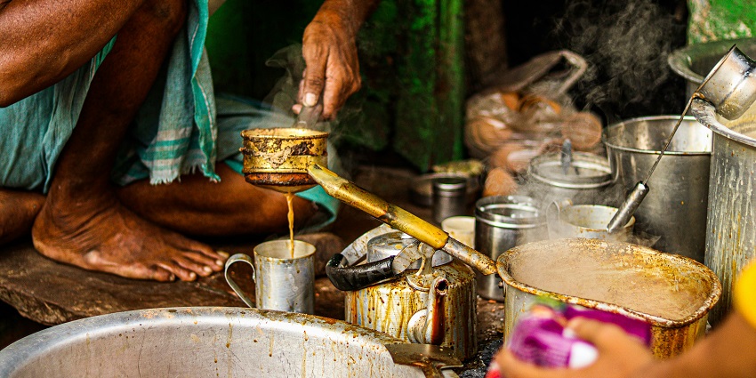 Two small earthen cups made of clay filled with hot chai served on a marble counter