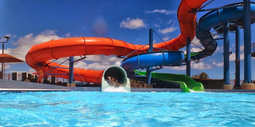 A waterslide leading into a pool, echoing the water attractions .