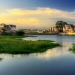 A beautiful sunrise over the Vaigai River in Madurai, Tamil Nadu, surrounded by greenery.