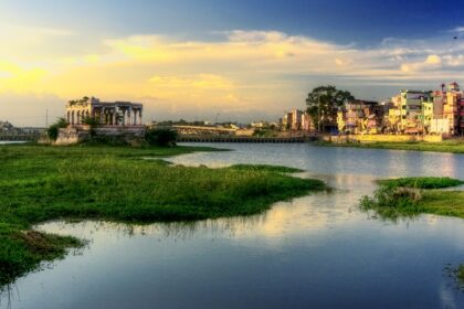 A beautiful sunrise over the Vaigai River in Madurai, Tamil Nadu, surrounded by greenery.