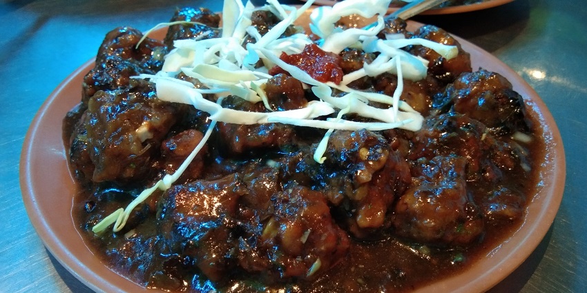 Manchurian, an Indo-Chinese dish, of fried veggie balls in a spicy, sweet and tangy sauce.