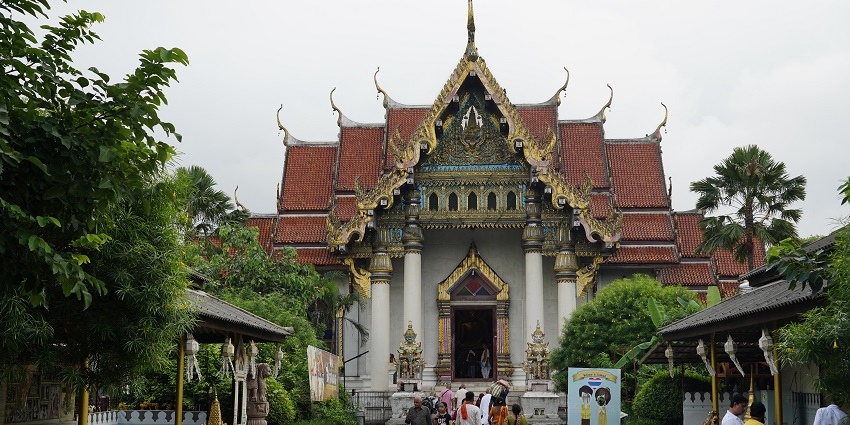 The V-shaped architectural entrance of the Thai Monastery at Bihar with tourists around.