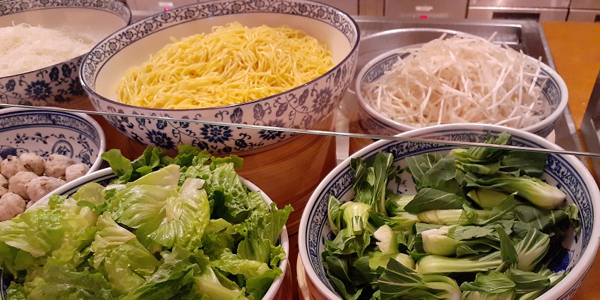 Variety of greens and noodles displayed on fancy chinaware bowls in a restaurant in Hyatt.
