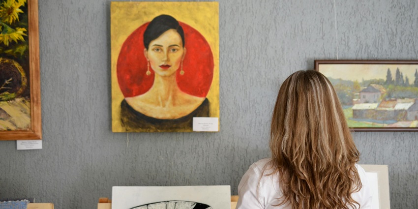 Image of a Woman Looking At Paintings Displayed On The Wall - The Bombay Art Society