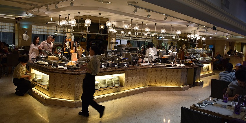 Kitchen staff busy serving at the buffet of the restaurant.