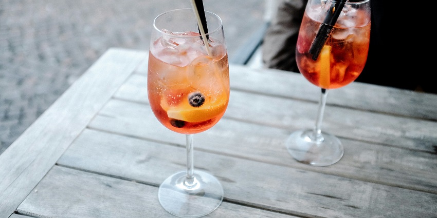Image of fruity cocktails in two fancy glassed served with fruits on top