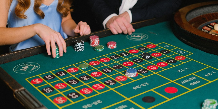 A person holding colorful casino chips, ready to place a bet in a game.