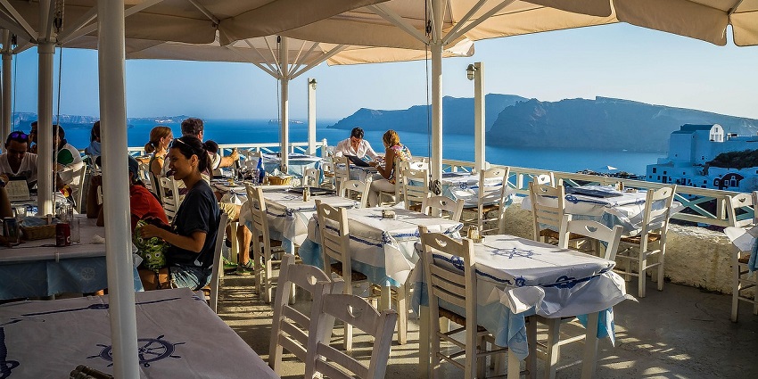 A picture of an elegant rooftop restaurant with majestic views of mountains in the background