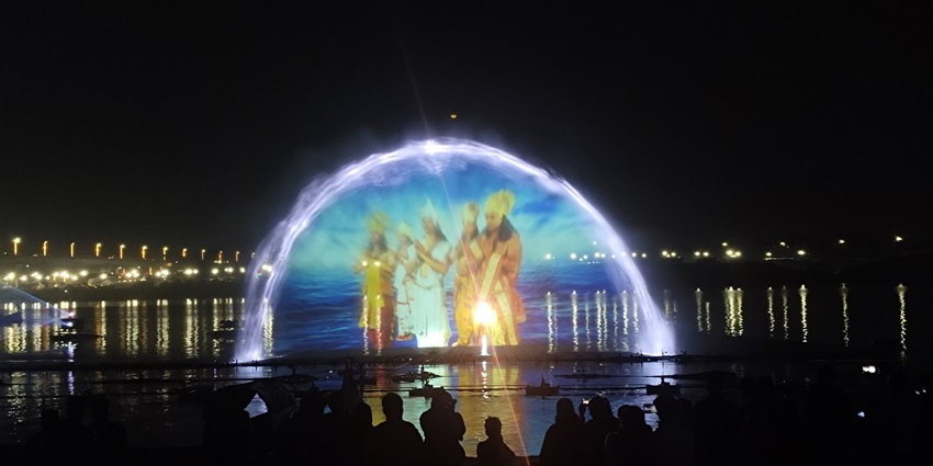 A picture of a laser show at a temple during nighttime depicting images of Hindu gods