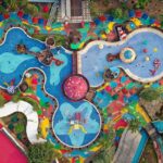 An aerial view of a floral-shaped pool and slides at an international water park