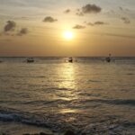 The beautiful sunset picture with boats on the water in Kuta, Bali, Indonesia.