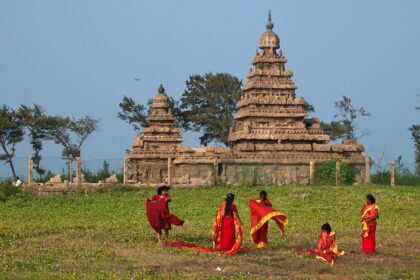 A picture of people walking in the garden of the ancient Shore Temple of Mahabalipuram.