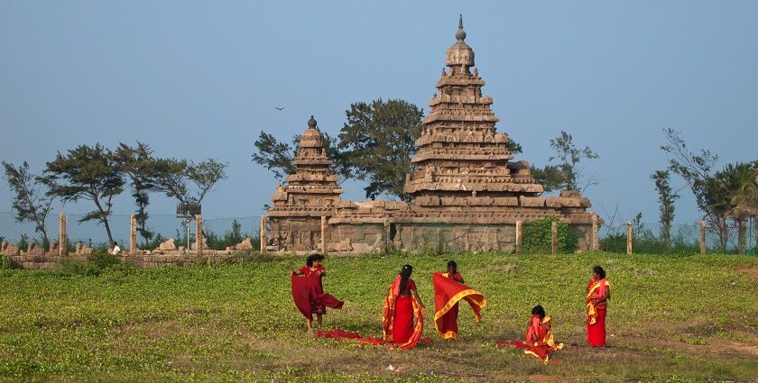 A picture of people walking in the garden of the ancient Shore Temple of Mahabalipuram.