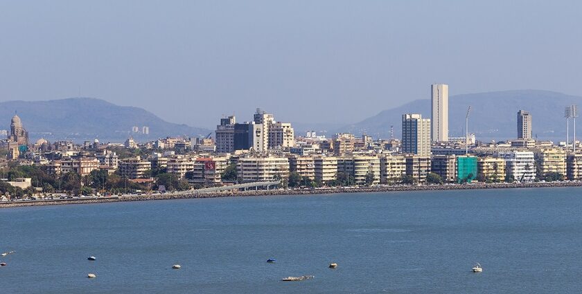 Panoramic view of Mumbai's skyline along Marine Drive against a sunset.