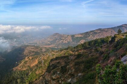 A breathtaking vista of green-capped mountains surrounded by lush green vegetation.