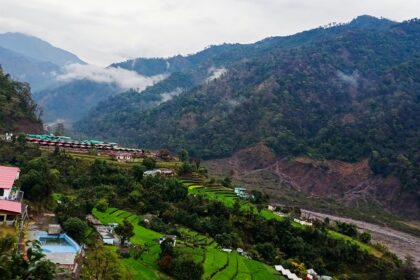 A glimpse of majestic peaks dotted with lush green vegetation and colourful houses.