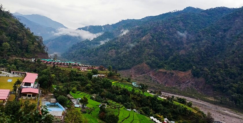 A glimpse of majestic peaks dotted with lush green vegetation and colourful houses.