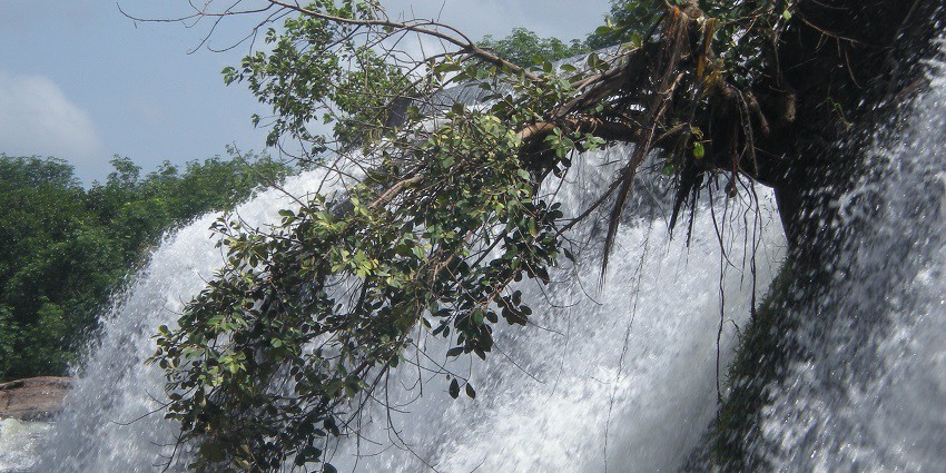 Thirparappu Waterfalls flowing over rocky terrain, surrounded by greenery in Kanyakumari.