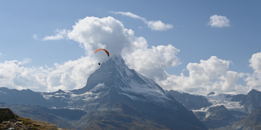 A paraglider glides gracefully above the iconic mountain in Ladakh.