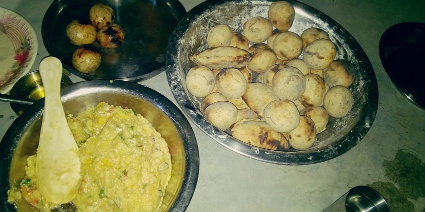 A plate can be seen full of littis in different shapes while the other plate is full of chokha.