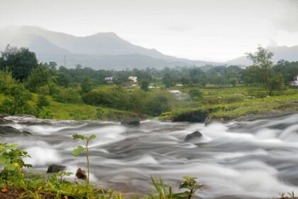 Explore places to visit in Karjat featuring lush green valleys and a stream of water.