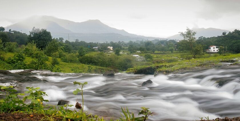 Explore places to visit in Karjat featuring lush green valleys and a stream of water.