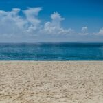 A panoramic view of Mandwa Beach with people engaging in various water sports.