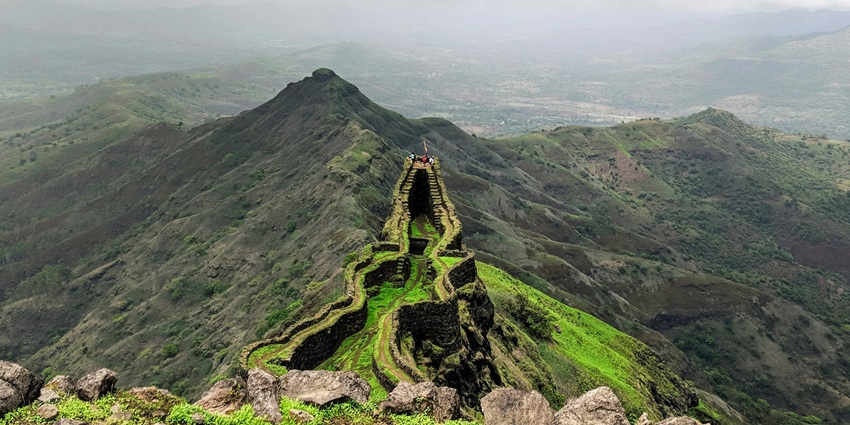 Torna Fort standing tall amidst rolling green hills and misty landscapes, rich in history.