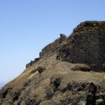 Entrance of Torna Fort, showcasing its ancient stone structure and natural surroundings.