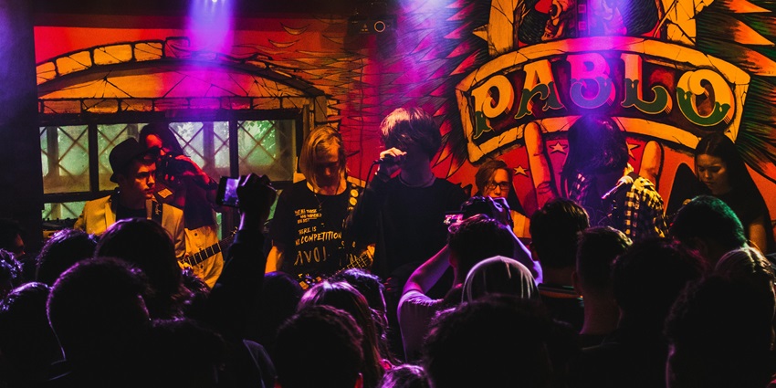 A picture of a live music performance at Toto's Garage, a funky bar with an automotive theme