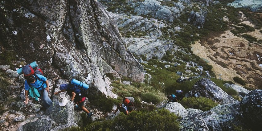 A glimpse of people trekking through the rustic terrains of majestic mountains.