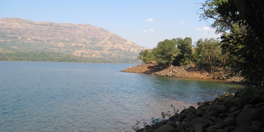 A beautiful view of Mulshi Dam surrounded by lush hills and blue waters.