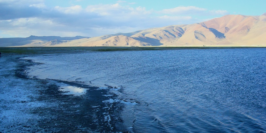 A picture of a lake near the Chumathang Hot Spring in Ladakh with a view of mountains
