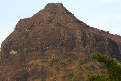 A view of Tung Fort bathed in sunlight, surrounded by green hills and a clear blue sky.