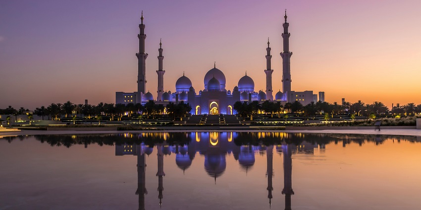 A picture of a mosque taken from a distance during nighttime