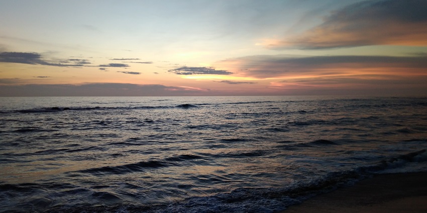 Experience the relaxed vision of dusk at Ullal Beach, where the sky meets the sea.