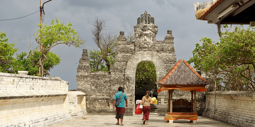 A breathtaking view of the magnificent Uluwatu Temple, situated atop a lush cliff.