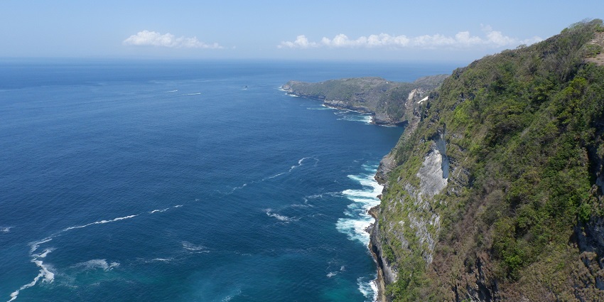 Beautiful view of the Pura Luhur Uluwatu Temple located on top of a seaside cliff in Bali.