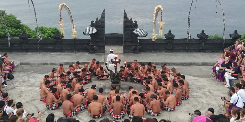 An image depicting a large group of people standing together in a Uluwatu Temple.