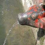 Water flowing from the spout shaped like a cow in Unapdev Hot Water Spring, Jalgaon