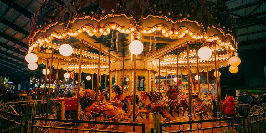 Image of a merry go round in a building with vibrant lights and stunning architecture