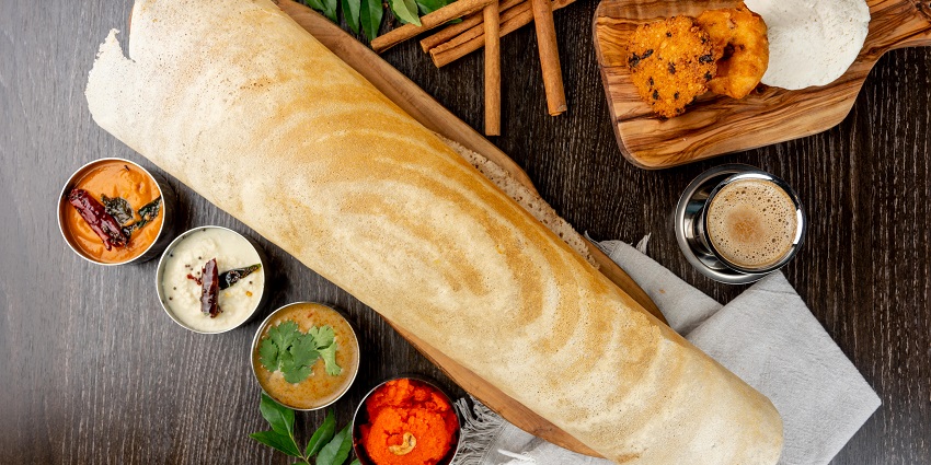 A dosa thali consisting of golden crisp dosa, sambar and coconut and tomato chutneys.